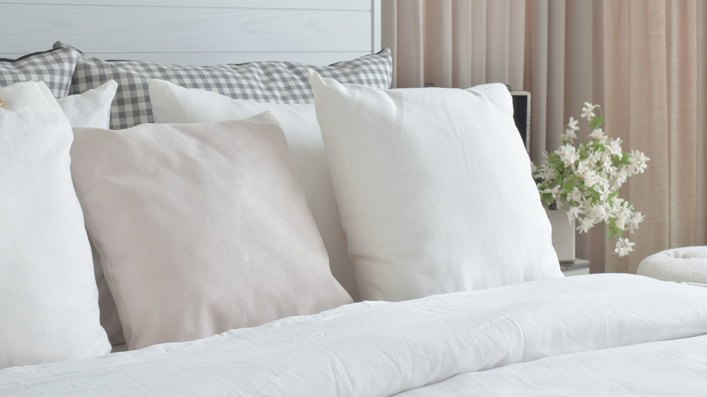 Neatly made bed with fluffy white pillows